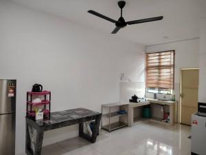 a kitchen with a table and a ceiling fan at De' Jamboree Homestay in Batu Gajah
