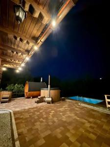 an outdoor patio at night with a guitar on it at Willa z widokiem na góry i jezioro - prywatny basen, sauna, balia in Międzybrodzie Bialskie