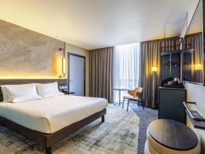 a hotel room with a bed and a desk at Novotel Liverpool Paddington Village in Liverpool