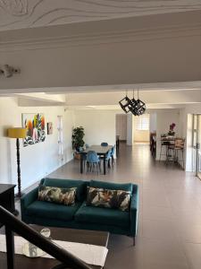 a living room with a green couch and a dining room at SM Exclusive Accommodation in Durban +10 photos