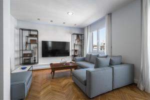 Una sala de estar con un sofá y un televisor de pantalla plana. en Aristotelous Penthouse by Luxlikehome, en Tesalónica