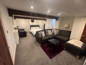 a living room with a couch and a bed at The basement in Bury