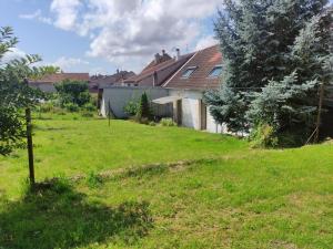 a house in a yard with a grass field at Maison Proche Gare in Neufchâteau