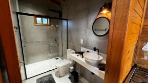 a bathroom with a toilet and a sink and a shower at Cabanas nos Canyons in Praia Grande +15 photos