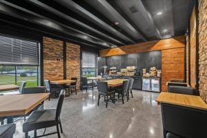 a dining room with tables and chairs and brick walls at Cobblestone Hotel & Suites Waukesha West Milwaukee in Waukesha