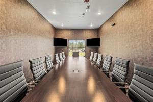 a conference room with a long table and chairs at Cobblestone Hotel & Suites Waukesha West Milwaukee in Waukesha