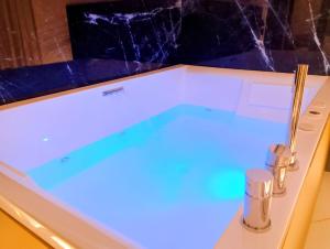 Incanto Suites Italy في نابولي: حوض استحمام مع إضاءة زرقاء في الحمام