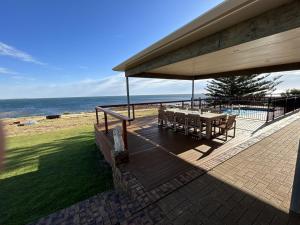 eine Terrasse mit einem Tisch und Stühlen am Strand in der Unterkunft Dukes of Yorkes - Wallaroo Beach Frontage - Entire Home in Wallaroo