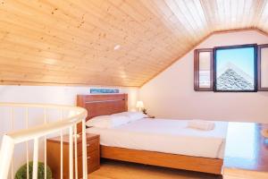 una camera da letto con un letto e un soffitto in legno di GuestReady - Magical refuge in Madeira a Ribeira da Janela