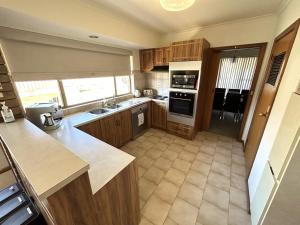 eine Küche mit Holzschränken und einer Arbeitsplatte in der Unterkunft Dukes of Yorkes - Wallaroo Beach Frontage - Entire Home in Wallaroo
