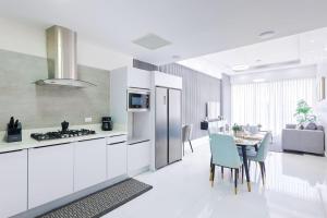 a kitchen with white cabinets and a table with chairs at Upscale Condo, Spectacular Views in Carlos Guerra
