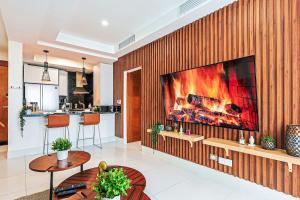 a living room with a large tv on a wooden wall at Cozy City-Center 1BD Condo, Pool in La Julia