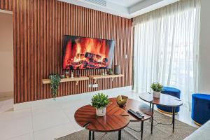 a living room with a table and a tv at Cozy City-Center 1BD Condo, Pool in La Julia