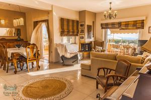 a living room with a table and a dining room at Ktima KiKa - Private Pool Escape & Tranquility in Kyparissia
