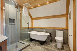 a bathroom with a tub and a toilet and a sink at Tremblant Prestige - Altitude 172-11 in Mont-Tremblant