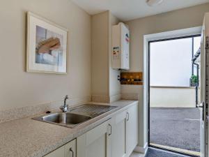 Una cocina con fregadero y puerta a un patio. en 4 Bed in Westward Ho 85367, en Westward Ho 52 fotos más