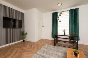 a living room with a table and green curtains at Northcote apartment in Hawick