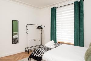 a bedroom with a bed and a window with green curtains at Northcote apartment in Hawick