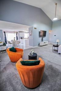 BelvidereにあるModern Comfort Loves Park - Stylish 3BR Getawayのリビングルーム(オレンジの椅子、テーブル付)