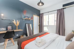 a bedroom with a bed with two towels on it at Phenom 1-Bedroom Apartment in Mar Mikhael in Al Mudawwar