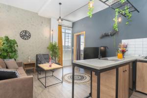 a kitchen and living room with a table and a couch at Phenom 1-Bedroom Apartment in Mar Mikhael in Al Mudawwar
