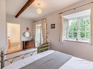 a bedroom with a bed and a window and a television at 1 Bed in Bourton-on-the-Water 44960 in Withington