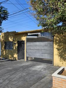 a garage door on a house with a gate at Acogedor loft estilo industrial in Posadas