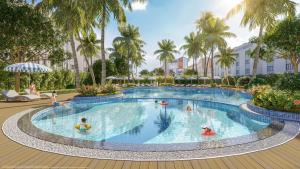 a group of people in a pool at a resort at StayLocal Apartment in Long Bình