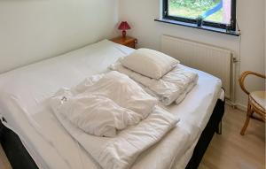 a bed with white sheets and pillows on it at Pet Friendly Home In Struer With Wifi in Humlum