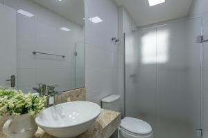 a white bathroom with a sink and a toilet at Melhor Apartamento centro Pomerode, perto de tudo in Pomerode +28 photos