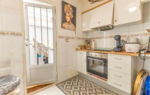 een kleine keuken met witte kasten en een raam bij Gorgeous Home In Orihuela With Wifi in Villamartin