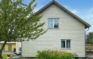 a white house with a window and a tree at 2 Bedroom Stunning Apartment In Bodafors in Bodafors +4 photos