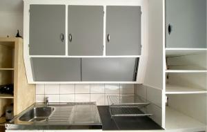 a kitchen with white cabinets and a sink at 2 Bedroom Stunning Apartment In Bodafors in Bodafors