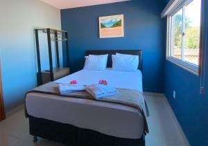 a bedroom with a large bed with blue walls at Pousada Menino do Rio in Búzios +32 photos
