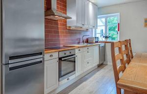 a kitchen with white cabinets and a stainless steel refrigerator at 3 Bedroom Gorgeous Home In Floby in Floby