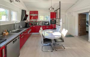 a kitchen with red cabinets and a table with chairs at Awesome Home In Brignoles in Brignoles