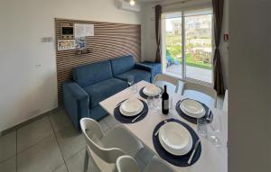 comedor con mesa y sofá azul en Lovely Apartment In Marzamemi With House Sea View, en Marzamemi
