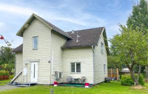 a white house with two chairs in the yard at 2 Bedroom Stunning Apartment In Bodafors in Bodafors +8 photos