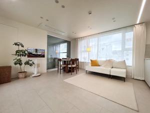 Una sala de estar con un sofá blanco y una mesa. en Private Rooftop Stay, en Gyeongju