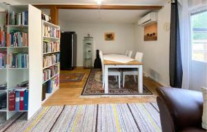 a living room with a table and bookshelves at 2 Bedroom Stunning Apartment In Bodafors in Bodafors