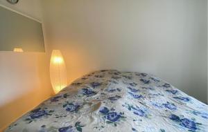 a bed with a blue and white comforter and a lamp at 2 Bedroom Stunning Apartment In Bodafors in Bodafors