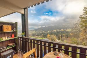 a balcony with a table and a view of the mountains at Face au Mont Blanc, plein sud in Cordon