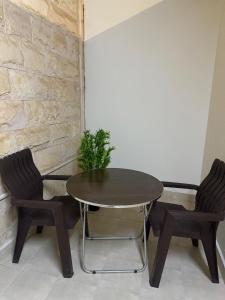 una mesa y dos sillas en una habitación en شقق لينا الخاصة, en Hail