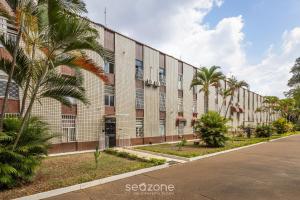 a building with palm trees in front of a street at Apto c/ Sefl Check-in na Asa Sul SQS0108 in Brasilia