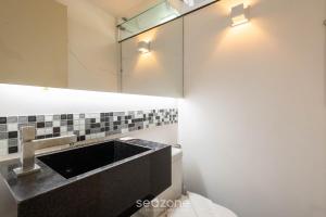 a bathroom with a sink and a mirror at Apto c/ Sefl Check-in na Asa Sul SQS0108 in Brasilia +17 photos