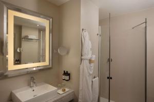 a white bathroom with a sink and a shower at NH Genova Centro in Genova