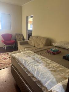 a large bed in a room with a couch at Casa Aconchegante in Barueri