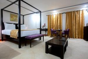a bedroom with a canopy bed and a table and chairs at Hôtel La Villa Racine in Dakar +82 photos