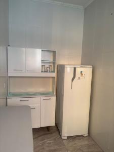 a kitchen with a refrigerator and white cabinets at Casa Aconchegante in Barueri