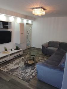 una sala de estar con un sofá y una mesa en RBG Apartament, en Bucarest